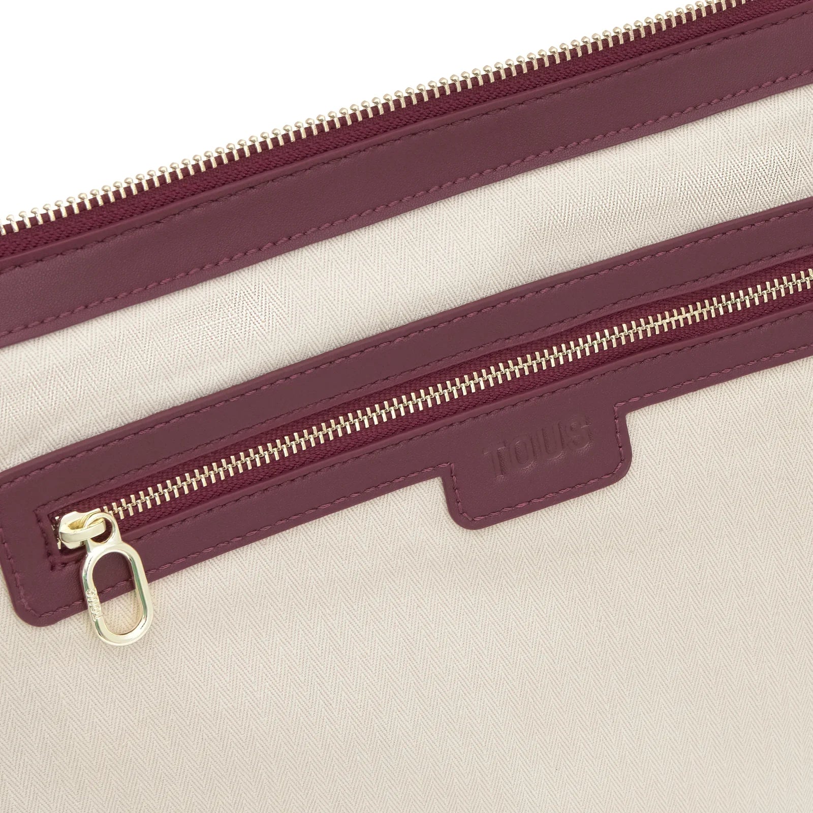 קלוז-אפ של תיק TOUS בצבע בז׳ עם רוכסים סגולים, מותג ב-CHOZEN מבית קבוצת אלפא