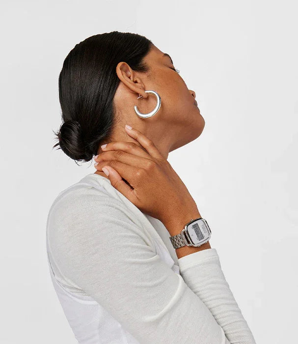 אישה עם חולצה לבנה, עגילי חישוק וכשעון כסוף, צילום תדמית לאופנה באתר CHOZEN