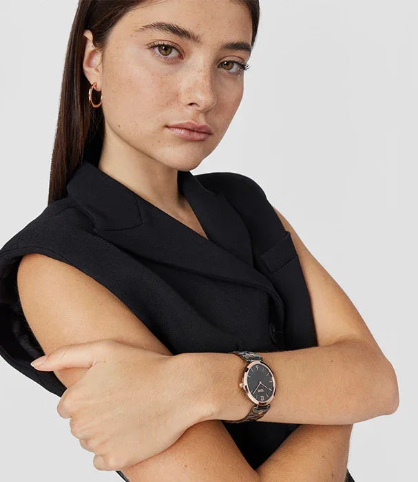 אישה עם גופייה שחורה, עונדת שעון יוקרתי מבית המותגים המובילים CHOZEN