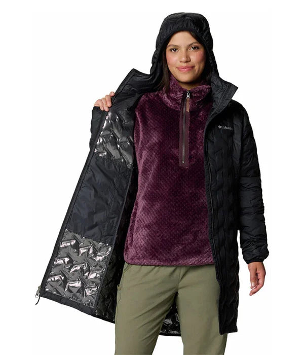 אישה לובשת מעיל שחור עם ברדס, פותחת את המעיל וחושפת סווטשרט סגול ממותג, אופנת חורף CHOZEN