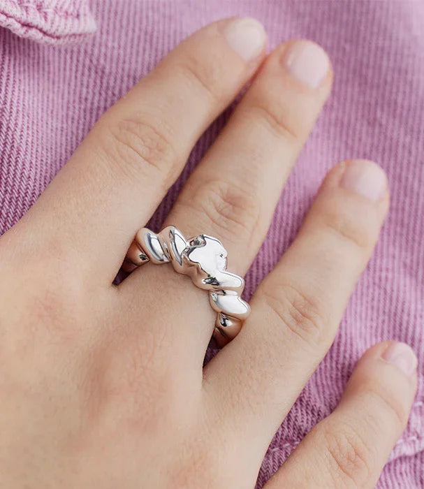 טבעת כסף מעוצבת על אצבע, רקע בד ורוד, תכשיט אופנה יוקרתי CHOZEN