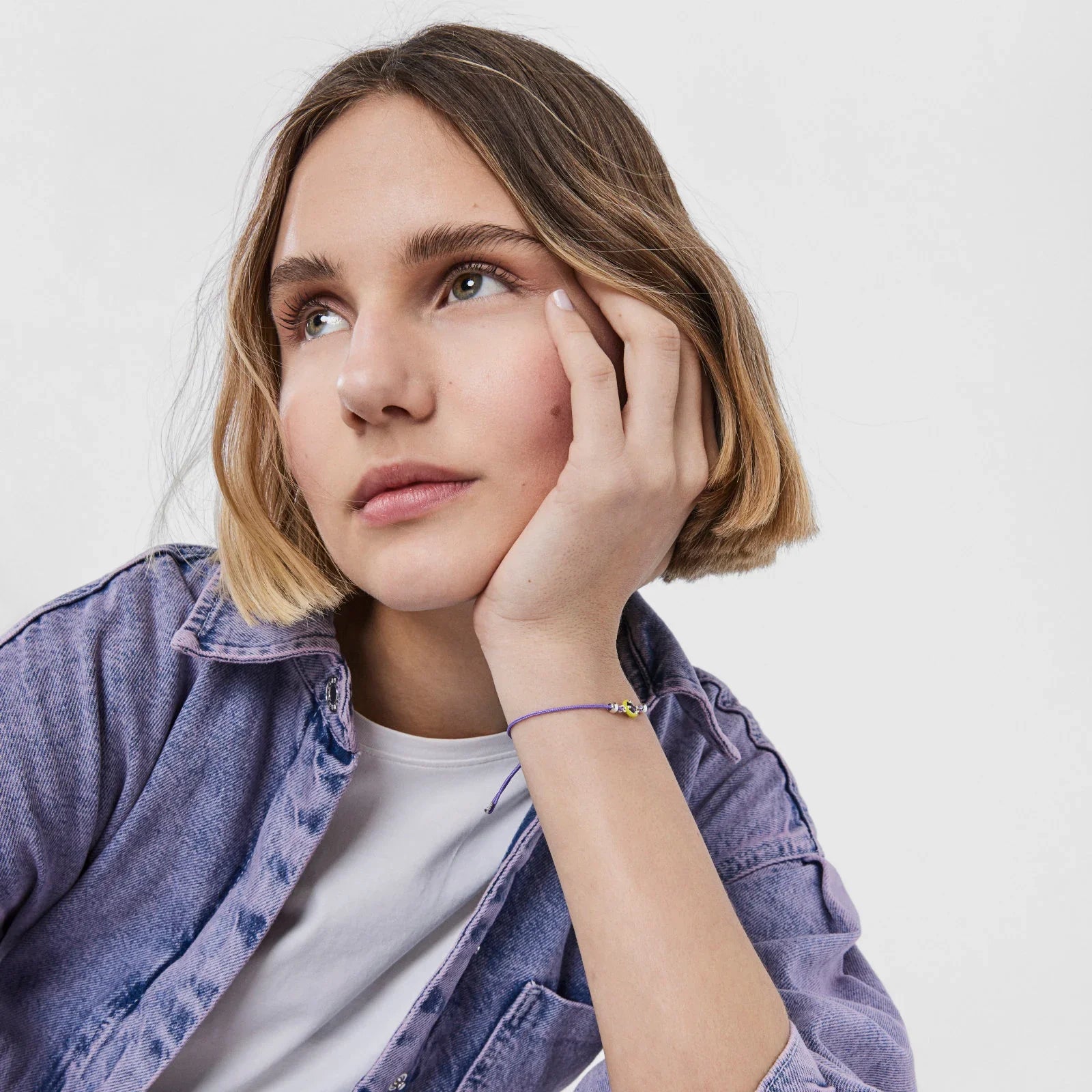 אישה צעירה לובשת חולצת ג'ינס סגולה, צמיד עדין, צילום סטודיו של CHOZEN מבית קבוצת אלפא