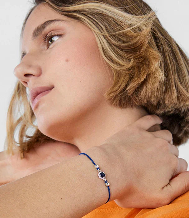 דוגמנית עם שיער קצר עונדת צמיד כחול עדין, צילום תקריב לאתר CHOZEN קבוצת אלפא