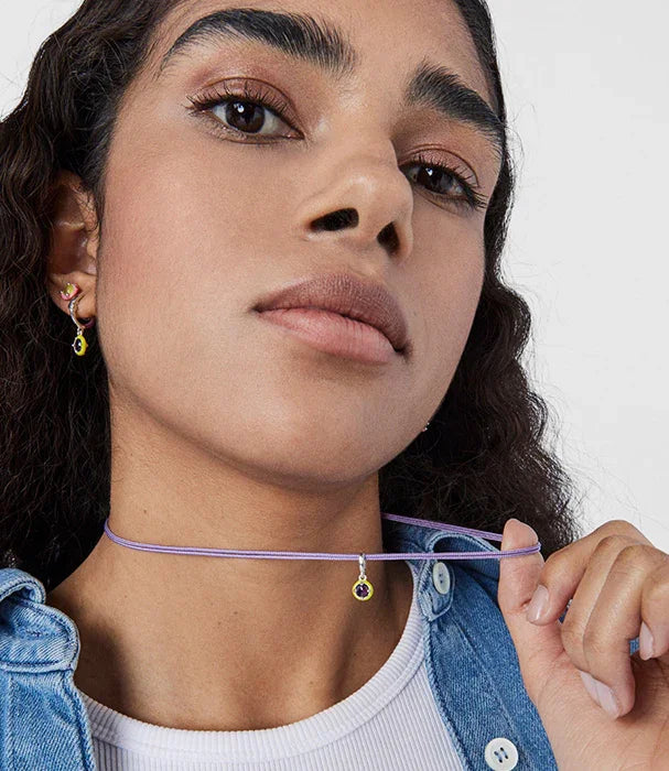 אישה עונדת שרשרת סגולה ועדינים עם קמע, עגילים תואמים, אופנת CHOZEN