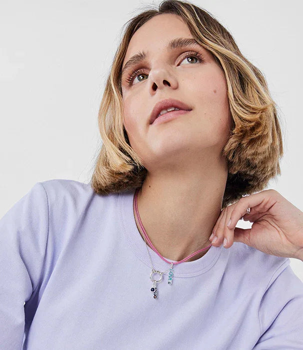 אישה עם שיער קצר ולבוש סווטשירט סגול ובה שרשרת אופנתית, צילום תדמית לאתר CHOZEN