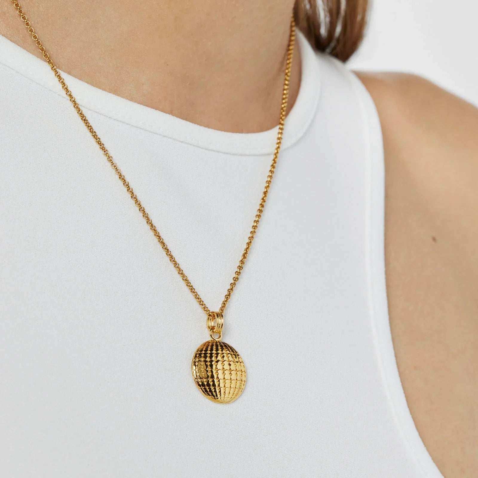 שרשרת זהב אופנתית עם תליון עגול על רקע חולצה לבנה, מבית CHOZEN