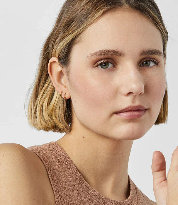 אישה צעירה עם שיער קצר, עונדת עגילי זהב, צילום תקריב לאתר CHOZEN מבית קבוצת אלפא