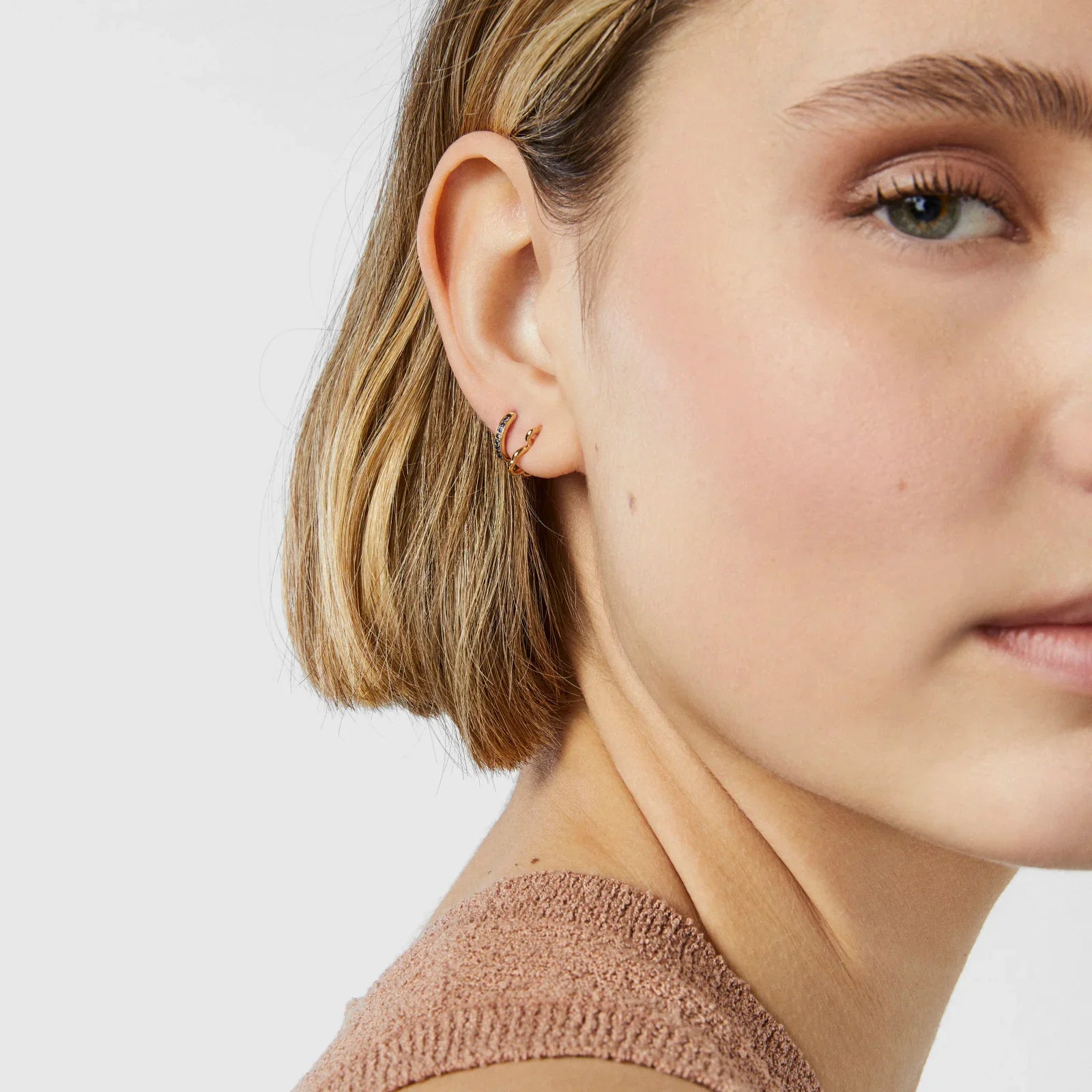 עגיל זהב עדין על אוזן של אישה, צילום תקריב, CHOZEN תכשיטים יוקרתיים