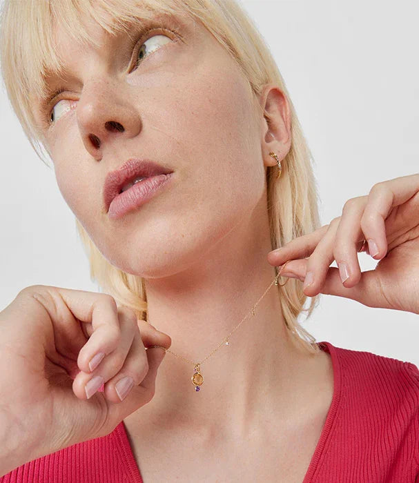 דוגמנית עם שרשרת זהב עדינה ותליון, עגילי זהב, רקע לבן, תכשיטים יוקרתיים CHOZEN