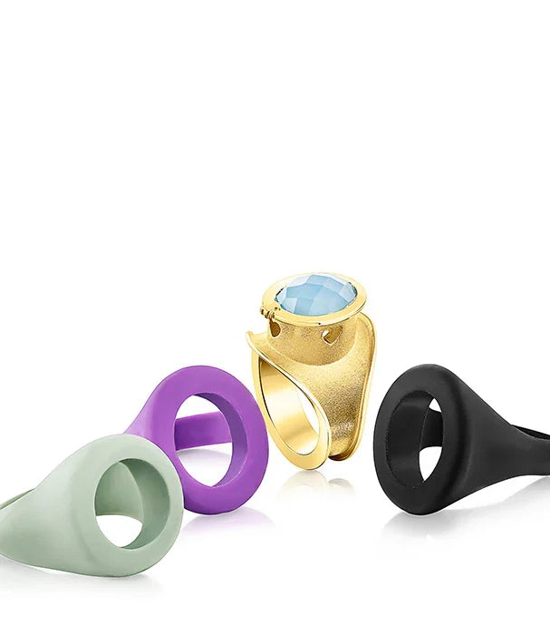 טבעת מוזהבת עם אבן כחולה ואביזרים בצבעים סגול, שחור וירוק, עיצוב ייחודי CHOZEN