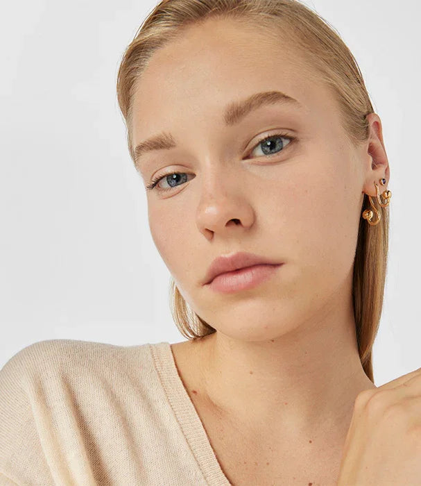 אישה עם שיער בלונדיני עונדת עגילי זהב טרנדיים, צילום סטודיו למותגים מובילים באתר CHOZEN