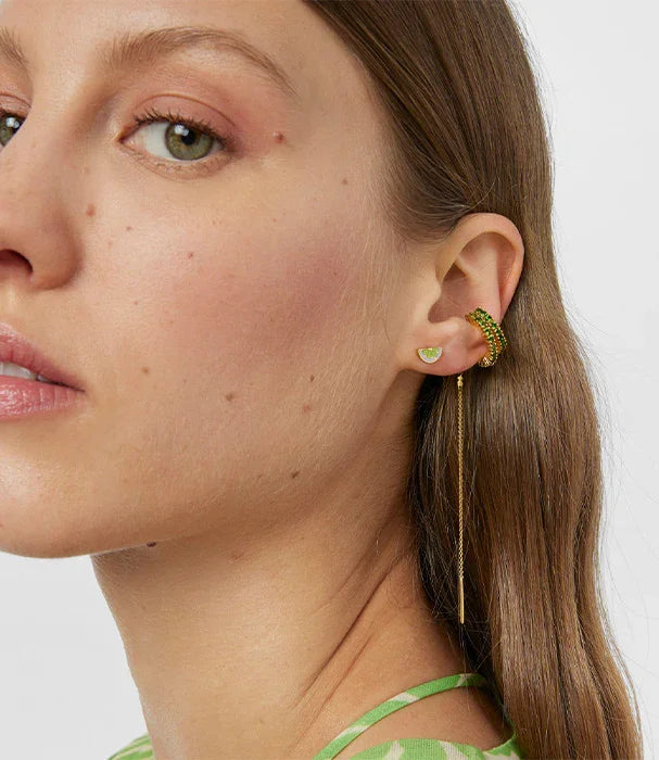 דוגמנית עונדת עגילי זהב ירוקים אופנתיים של CHOZEN על אוזן, צילום תקריב אופנה