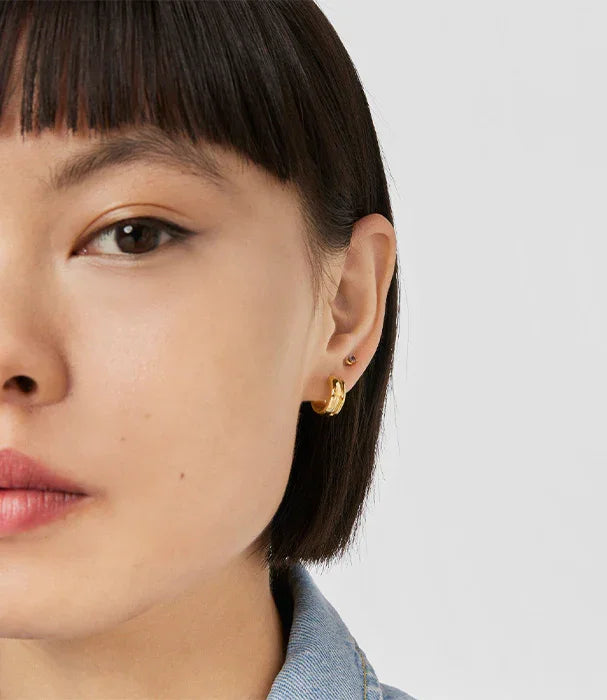 אישה עם עגיל זהב עדין על אוזן שמאל, צילום תקריב, תכשיטים יוקרתיים CHOZEN