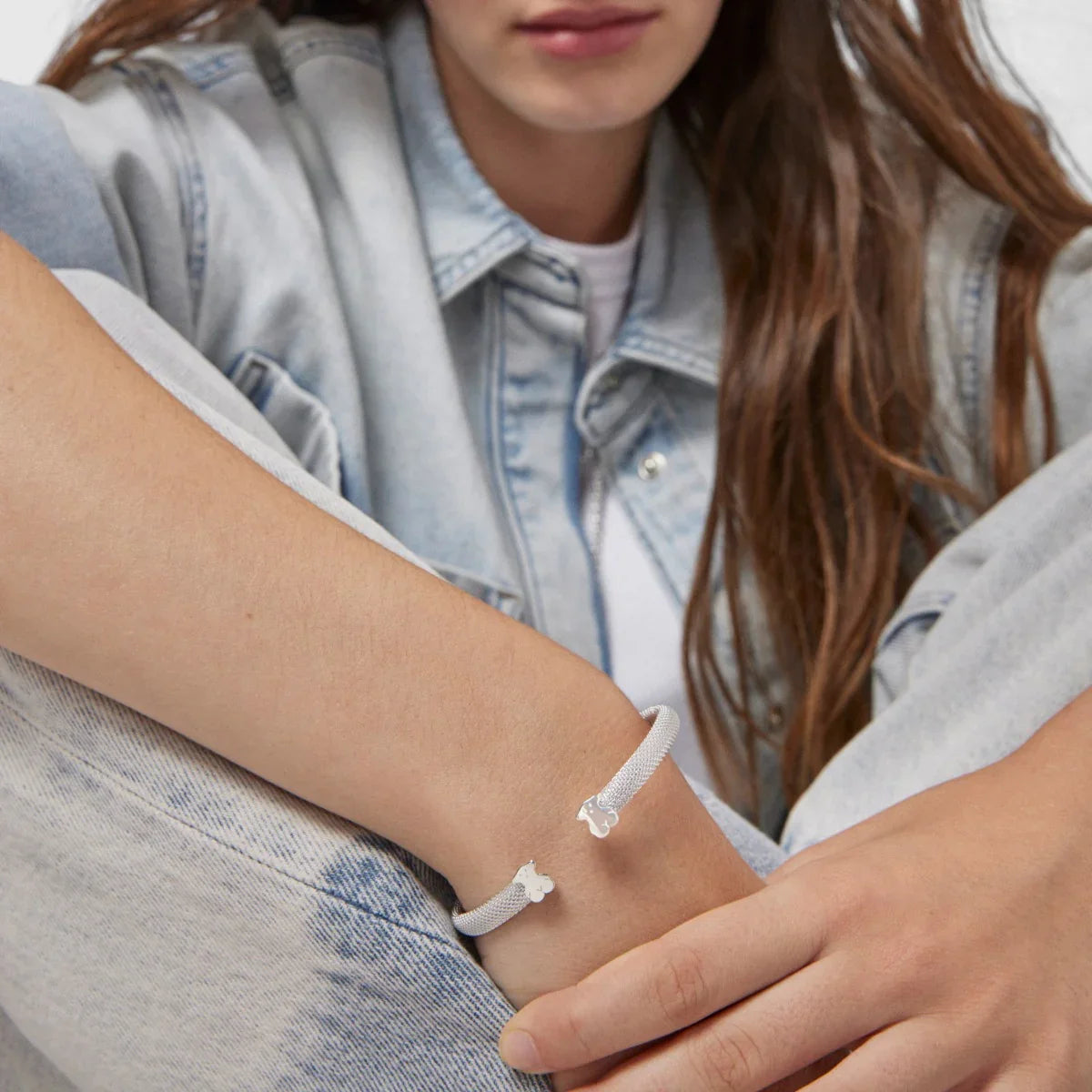 צמיד כסף מעוצב על יד של אישה בלבוש ג'ינס, צילום תדמית אתר CHOZEN