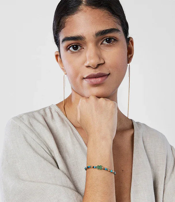 אישה עונדת עגילי חישוק זהב וצמיד חרוזים צבעוני, צילום אופנה CHOZEN