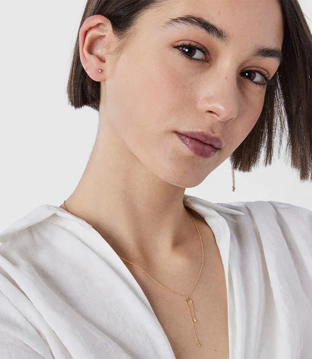 אישה עונדת שרשרת זהב אופנתית, בלבוש לבן, צילום תקריב לפרסום תכשיטים ב-CHOZEN