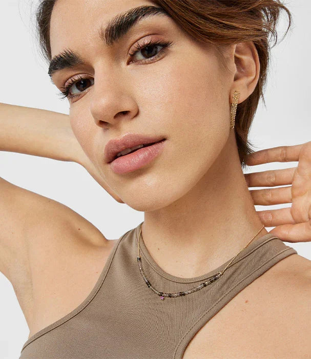 אישה עם עגיל תלוי זהב ושרשרת עדינה, צילום תקריב, אופנה CHOZEN