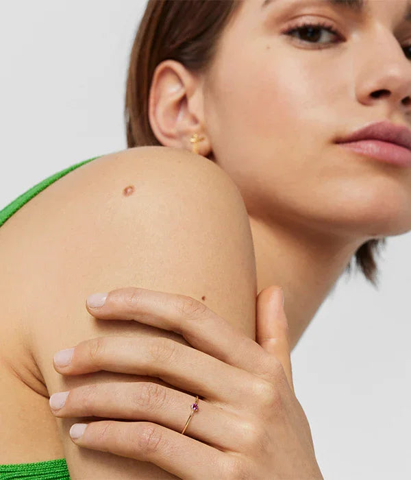 אישה עם עגיל זהב וטבעת עדינה עם אבן סגולה, אופנה מודרנית, CHOZEN מותגים מובילים