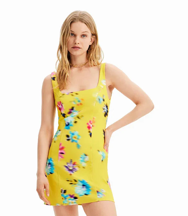 אישה לובשת שמלת מיני צהובה עם הדפס פרחוני צבעוני, אופנה CHOZEN