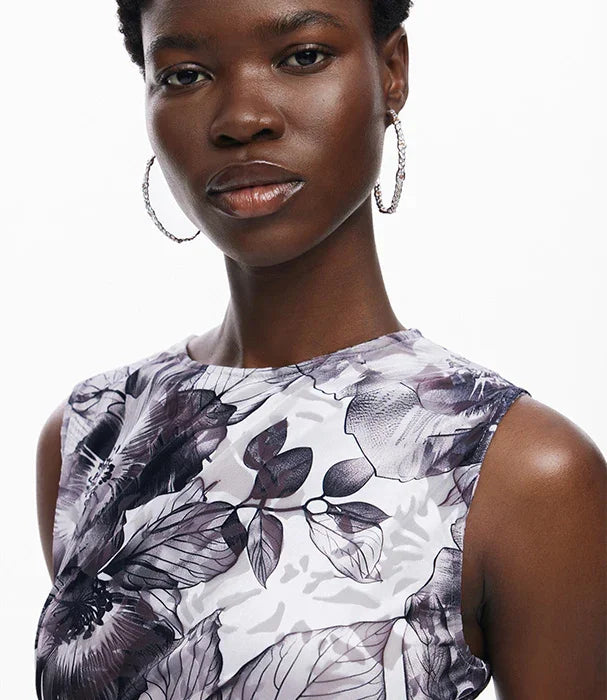 אשה עונדת עגילים בשמלת קיץ מודפסת פרחים, אופנה באתר CHOZEN