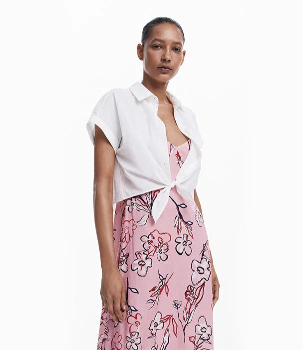אישה עם שמלה ורודה בהדפס פרחוני ועליה חולצה לבנה קצרה, אופנה טרנדית ב-CHOZEN