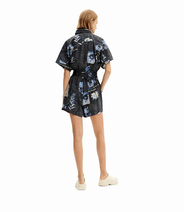 אישה עם אוברול קצר שחור עם הדפס פרחים כחולים, אופנה עדכנית מ-CHOZEN