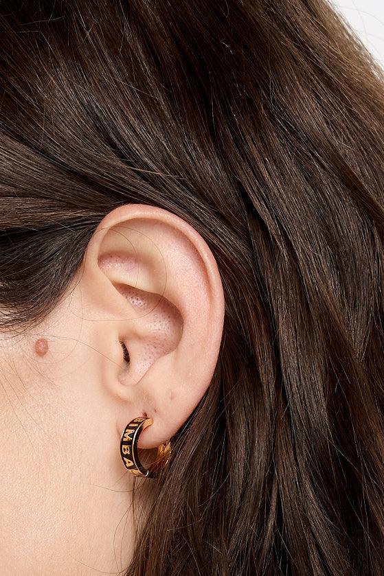 עגיל חישוק זהב שחור על אוזן עם שיער חום, צ׳וזן תכשיטים מבית קבוצת אלפא