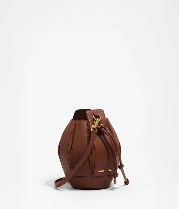 תיק דלי חום מעור עם רצועה, מותג BIMBA Y LOLA, מוצג על רקע לבן באתר CHOZEN