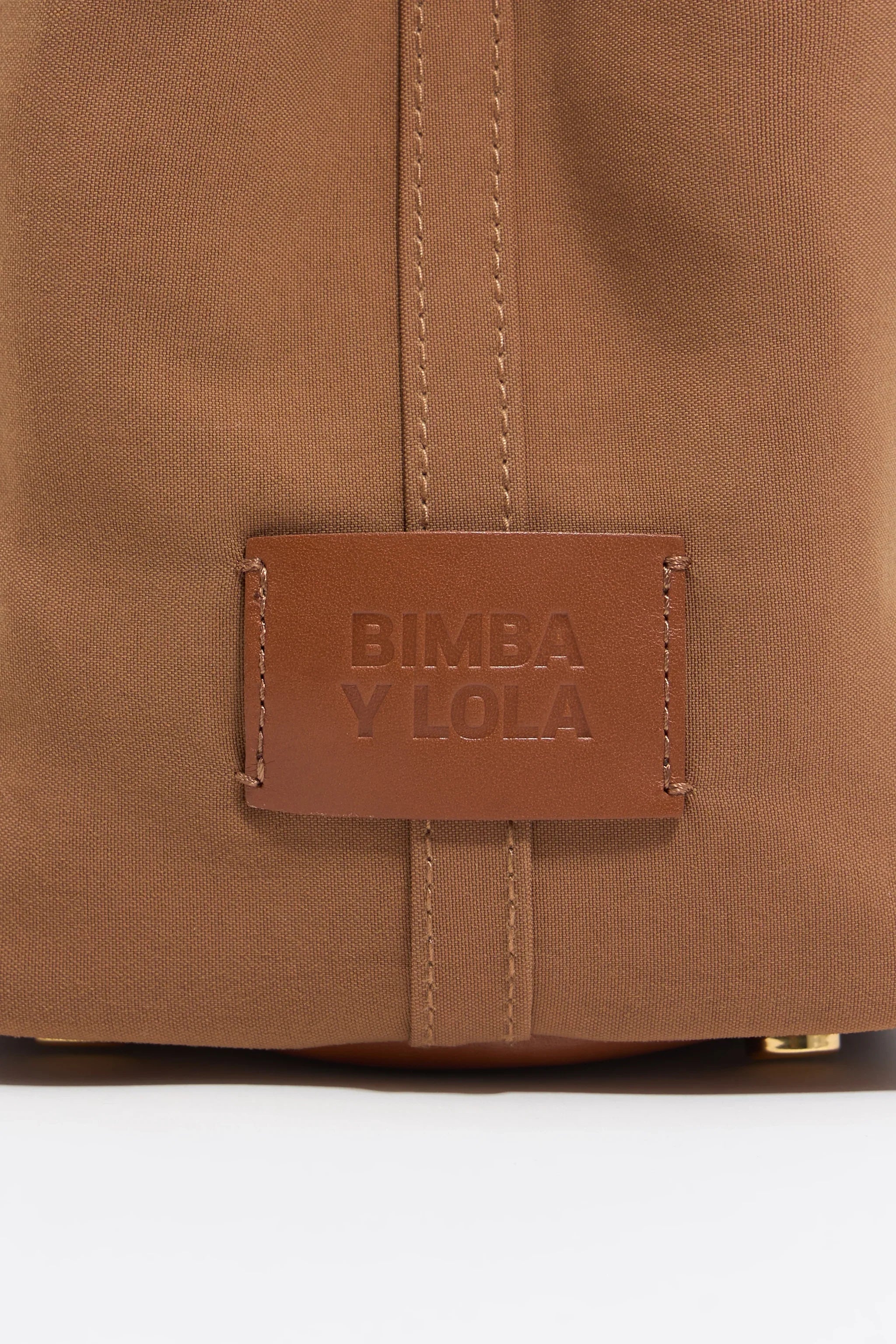 תקריב של תיק חום מבד עם תג עור ממותג BIMBA Y LOLA, נמכר ב-CHOZEN מותגים מובילים