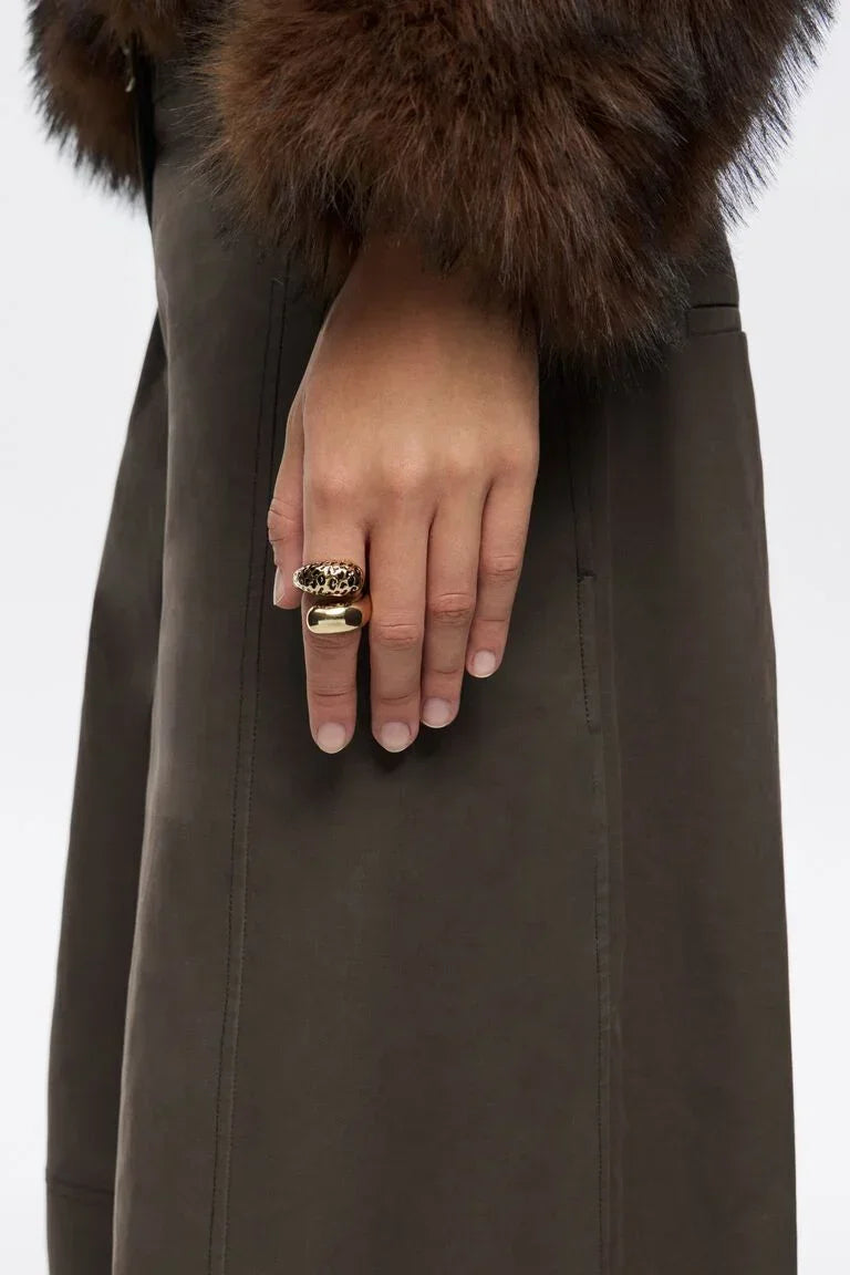 יד עם טבעות זהב מעוצבות, מעיל כהה ושרוול פרווה, אופנה יוקרתית CHOZEN