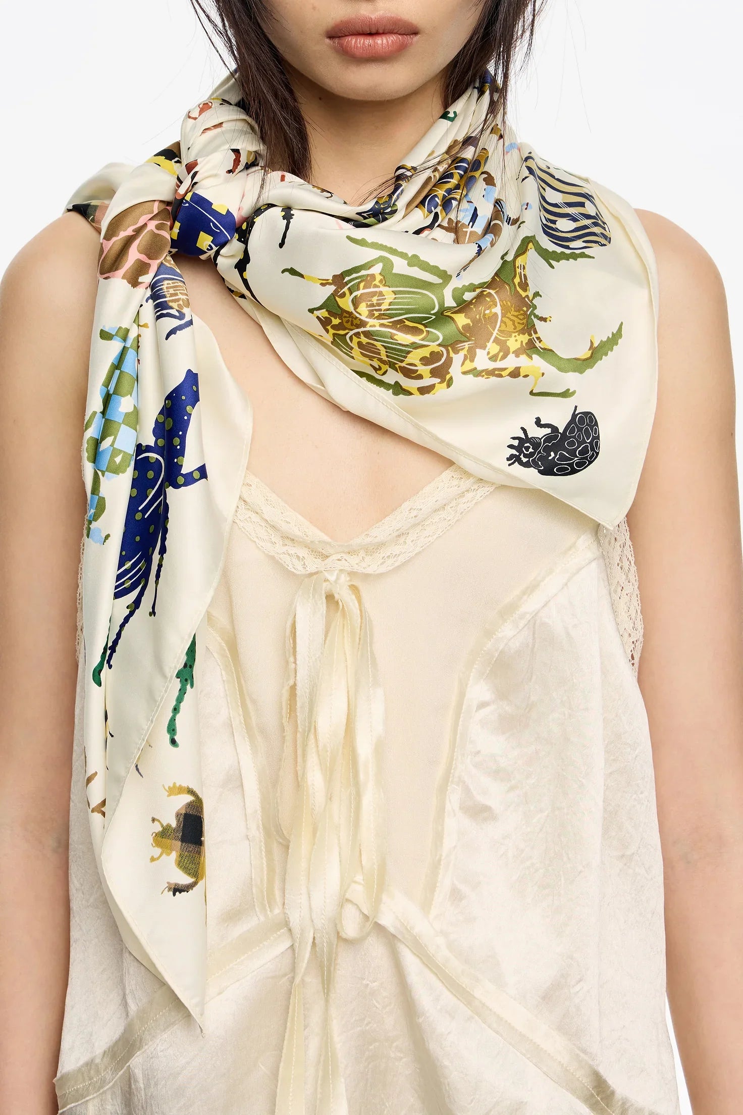 צעיף משי מעוצב עם הדפס חיפושיות צבעוניות, על גבי חולצה בהירה, צילום לאתר CHOZEN