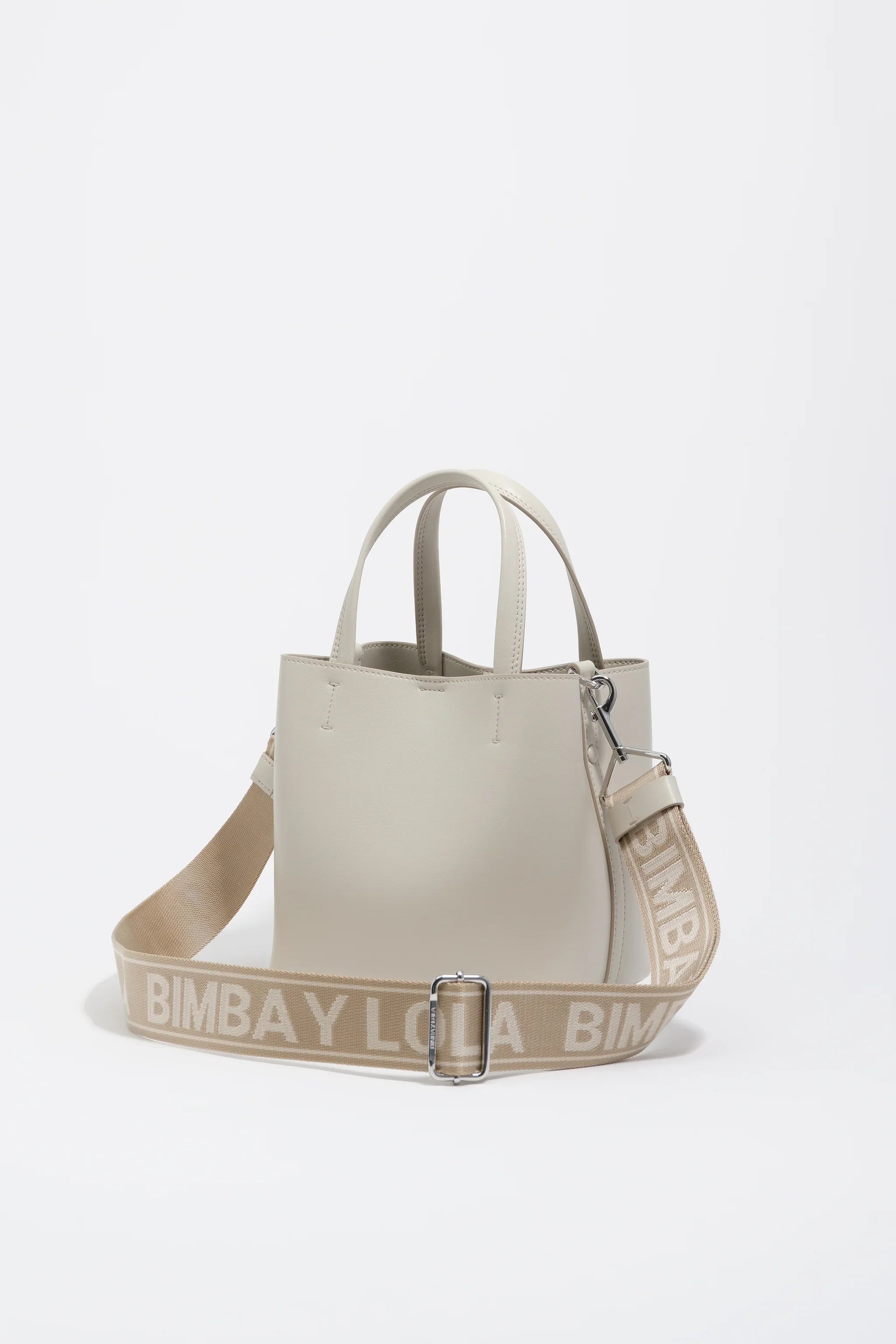 תיק יד מעור בצבע בז' עם רצועה רחבה ממותגת BIMBAY LOLA, מצולם על רקע לבן. מותגי יוקרה ב-CHOZEN.