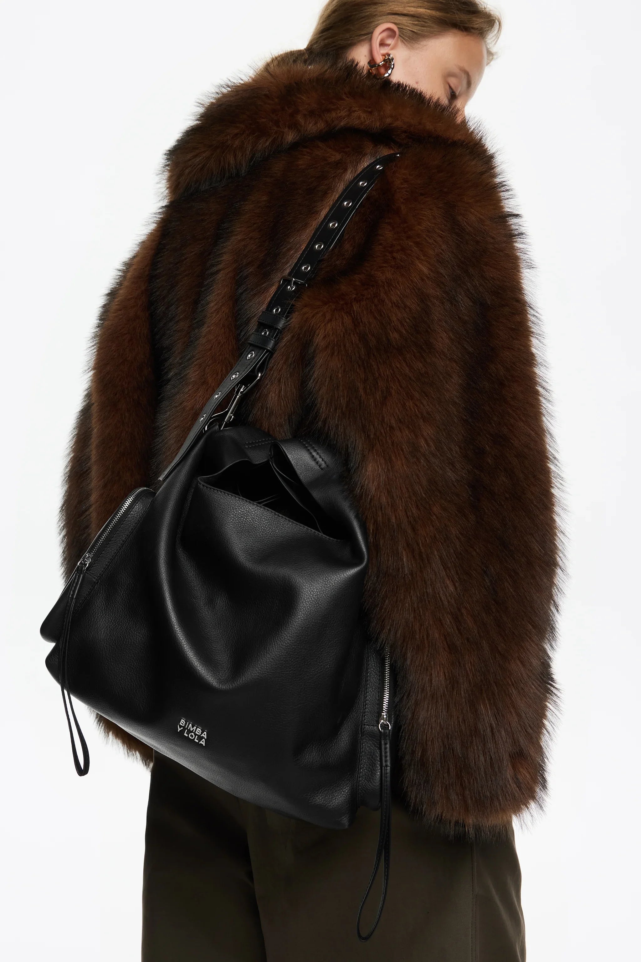 אישה עם מעיל פרווה חום ותיק עור שחור מבית BIMBA Y LOLA, אופנה יוקרתית CHOZEN