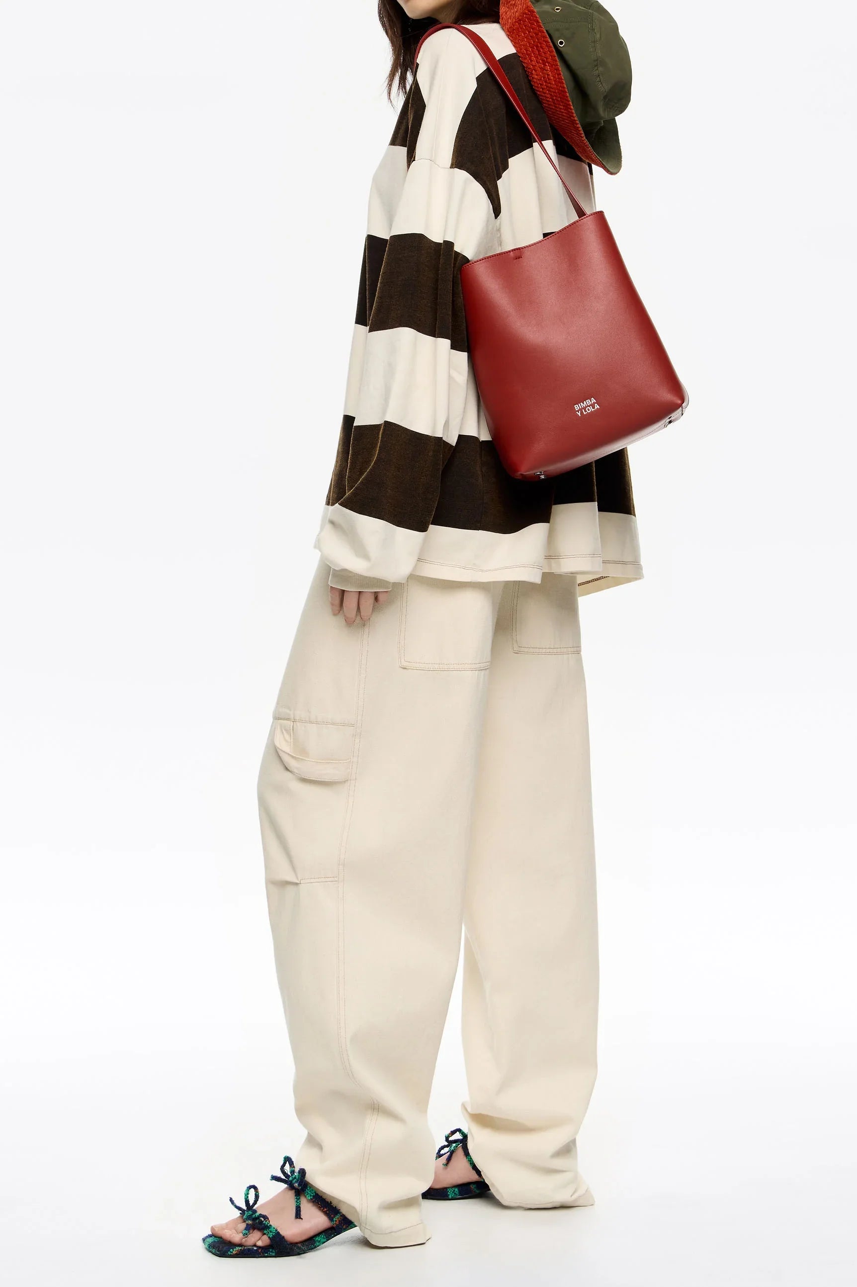 אופנת נשים באתר CHOZEN: דגם עם סווטשירט מפוספס, תיק עור אדום, מכנסי בז', כפכפים צבעוניים