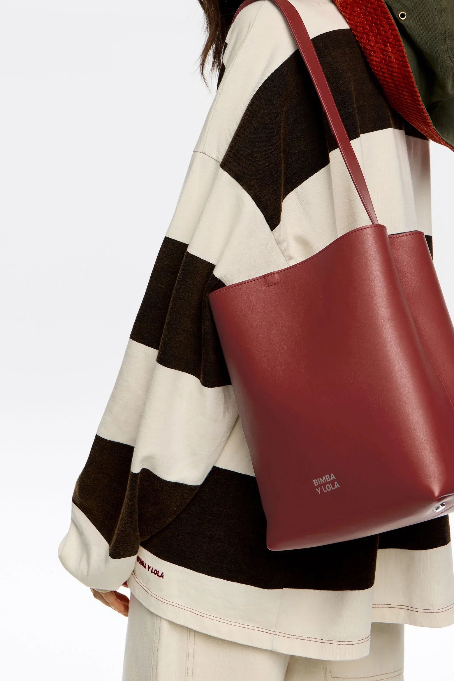 תיק עור בורדו של BIMBA Y LOLA על מודל עם חולצה פסים, אופנה יוקרתית CHOZEN