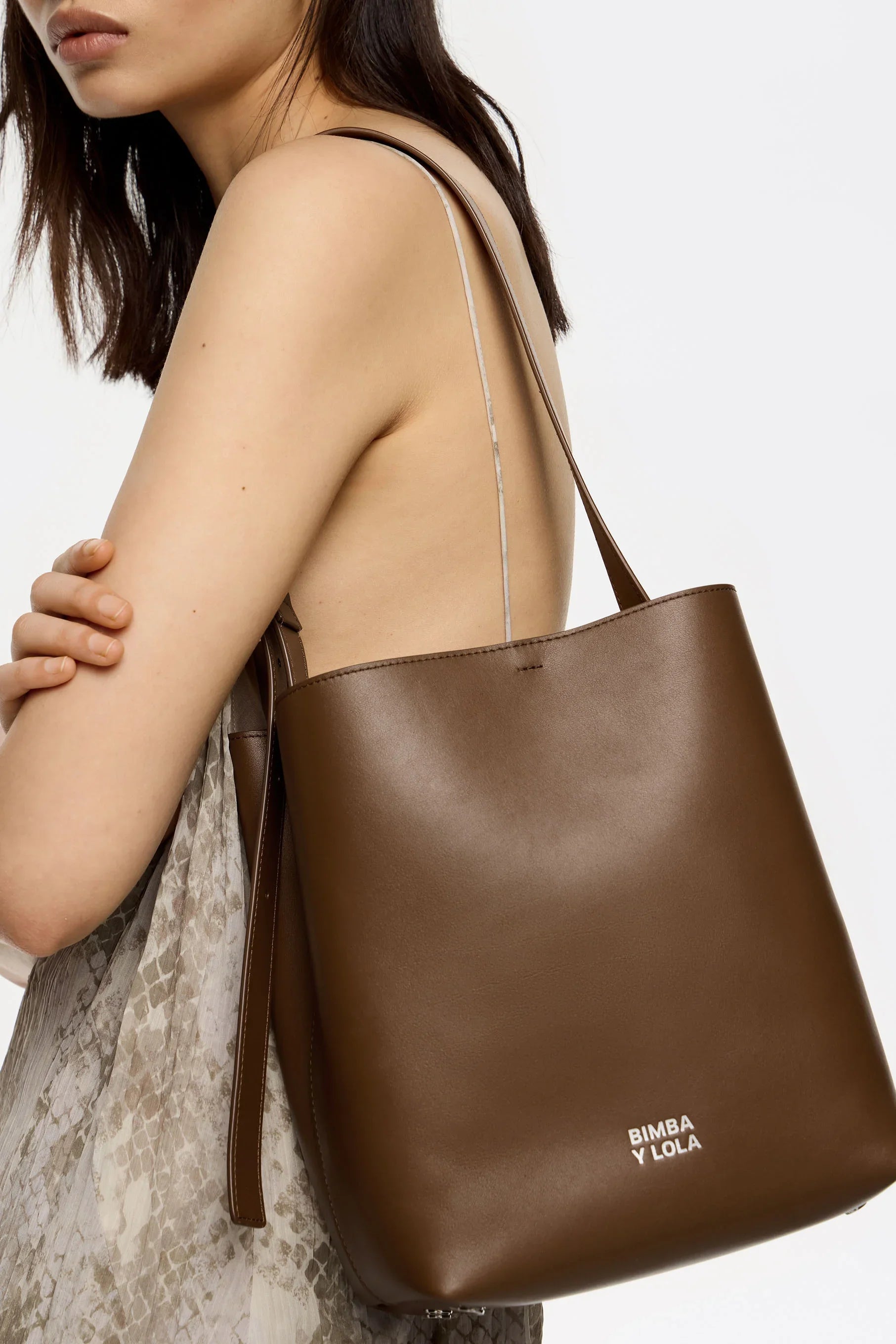 דגם גב של אישה עם תיק עור חום של BIMBA Y LOLA מקולקציית המותגים ב-CHOZEN