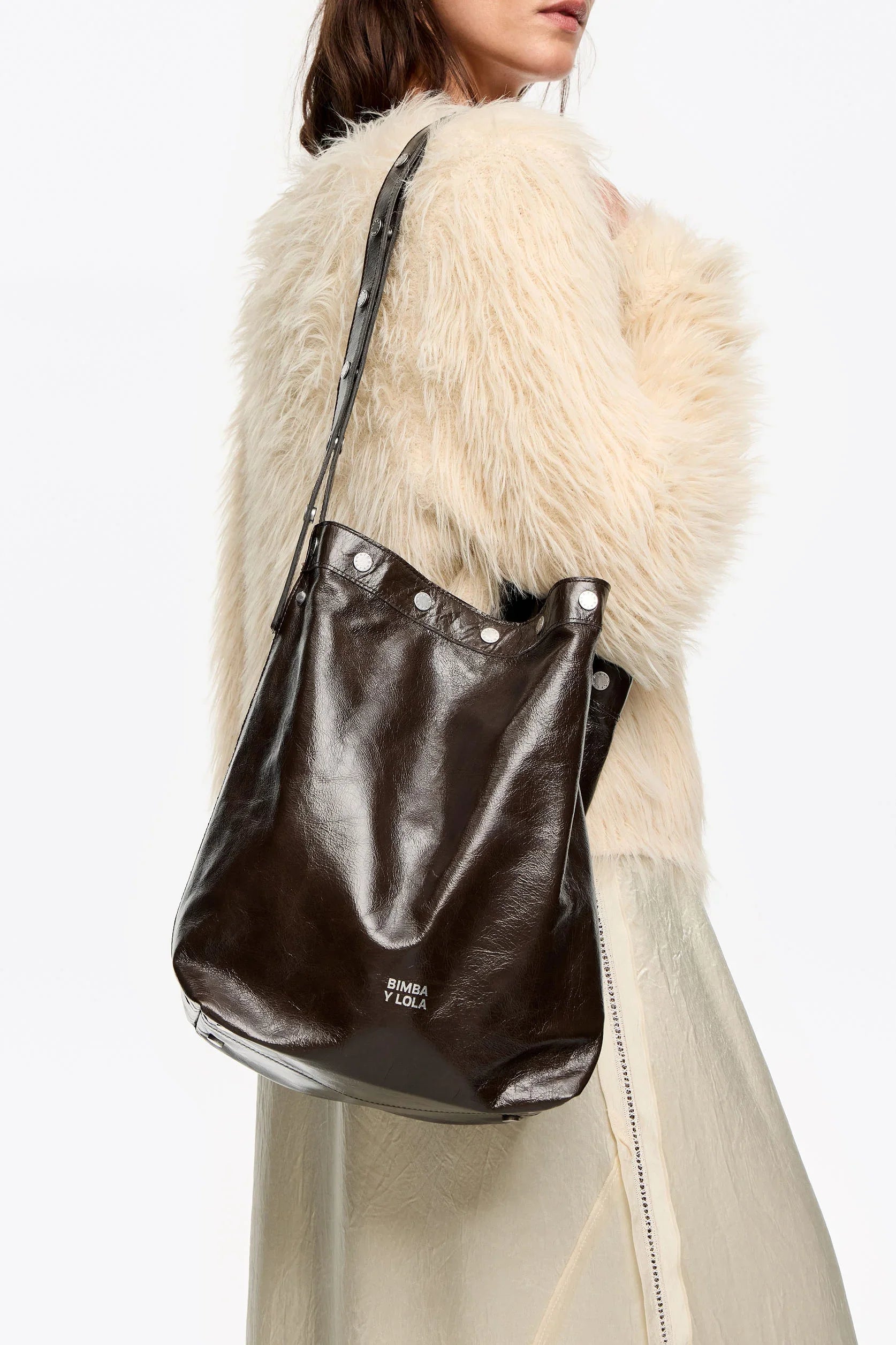 תיק עור שחור Bimba Y Lola על כתף של דוגמנית עם מעיל פרווה, אופנה יוקרתית מ-CHOZEN