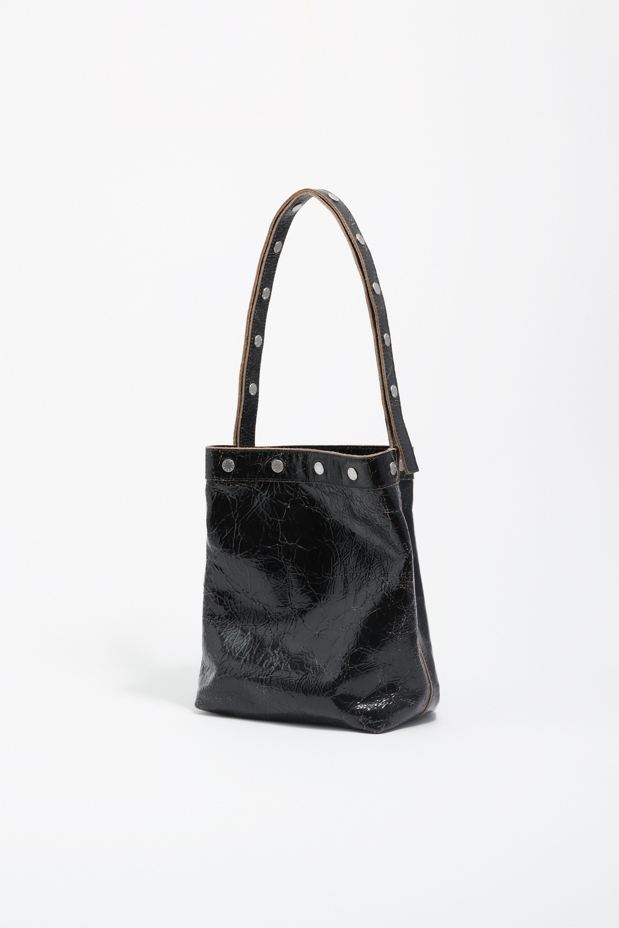 תיק יד שחור מעור מבריק עם ניטים, אופנה יוקרתית CHOZEN, צילום על רקע לבן