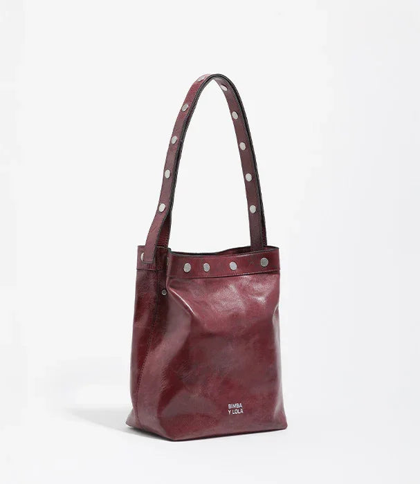 תיק יד מעור סגול מבית BIMBA Y LOLA עם ניטים, מוצג ב-CHOZEN, יבואן רשמי של מותגים מובילים