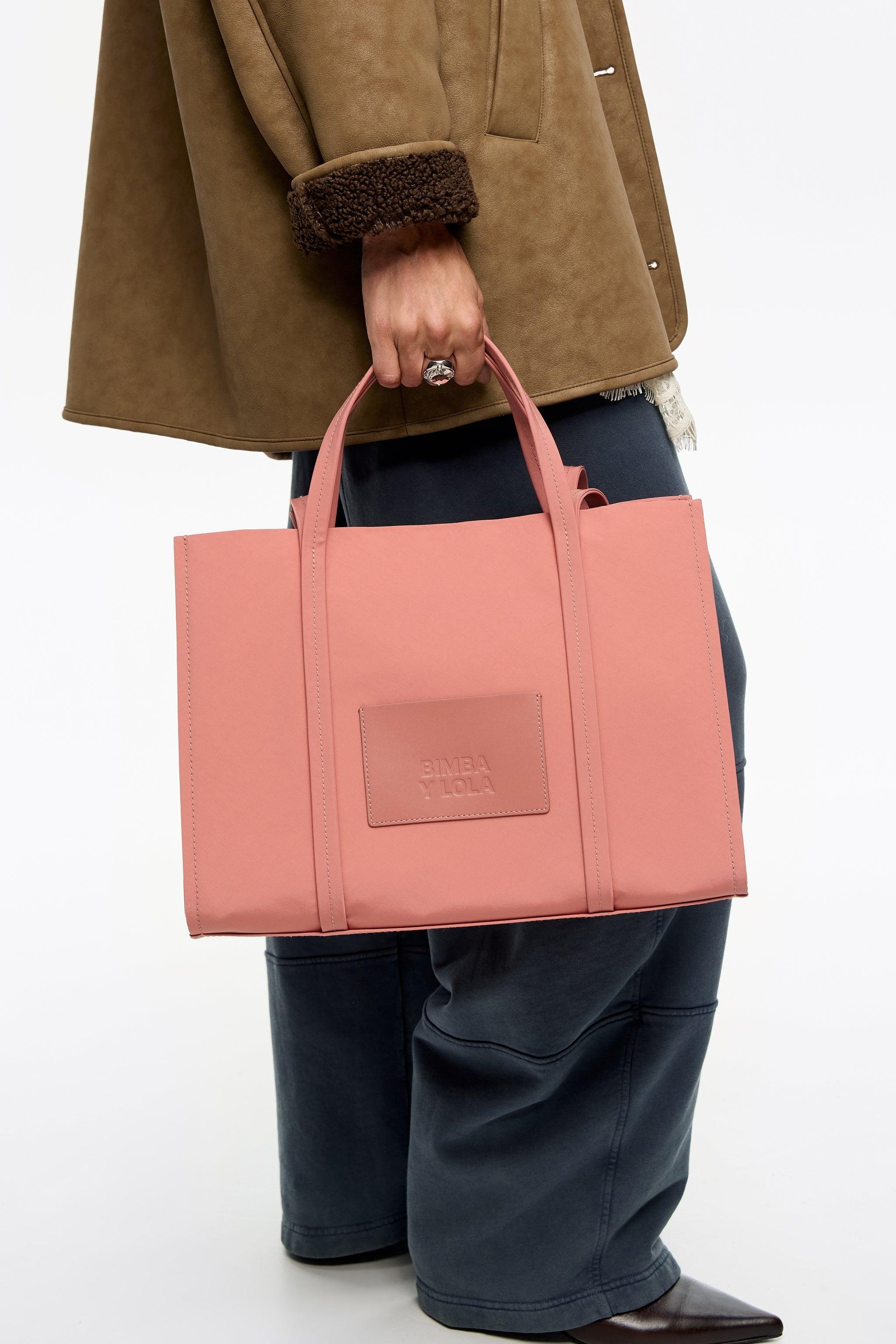 תיק ורוד מבית BIMBA Y LOLA מוחזק ביד, אופנה יוקרתית ב-CHOZEN, קבוצת אלפא