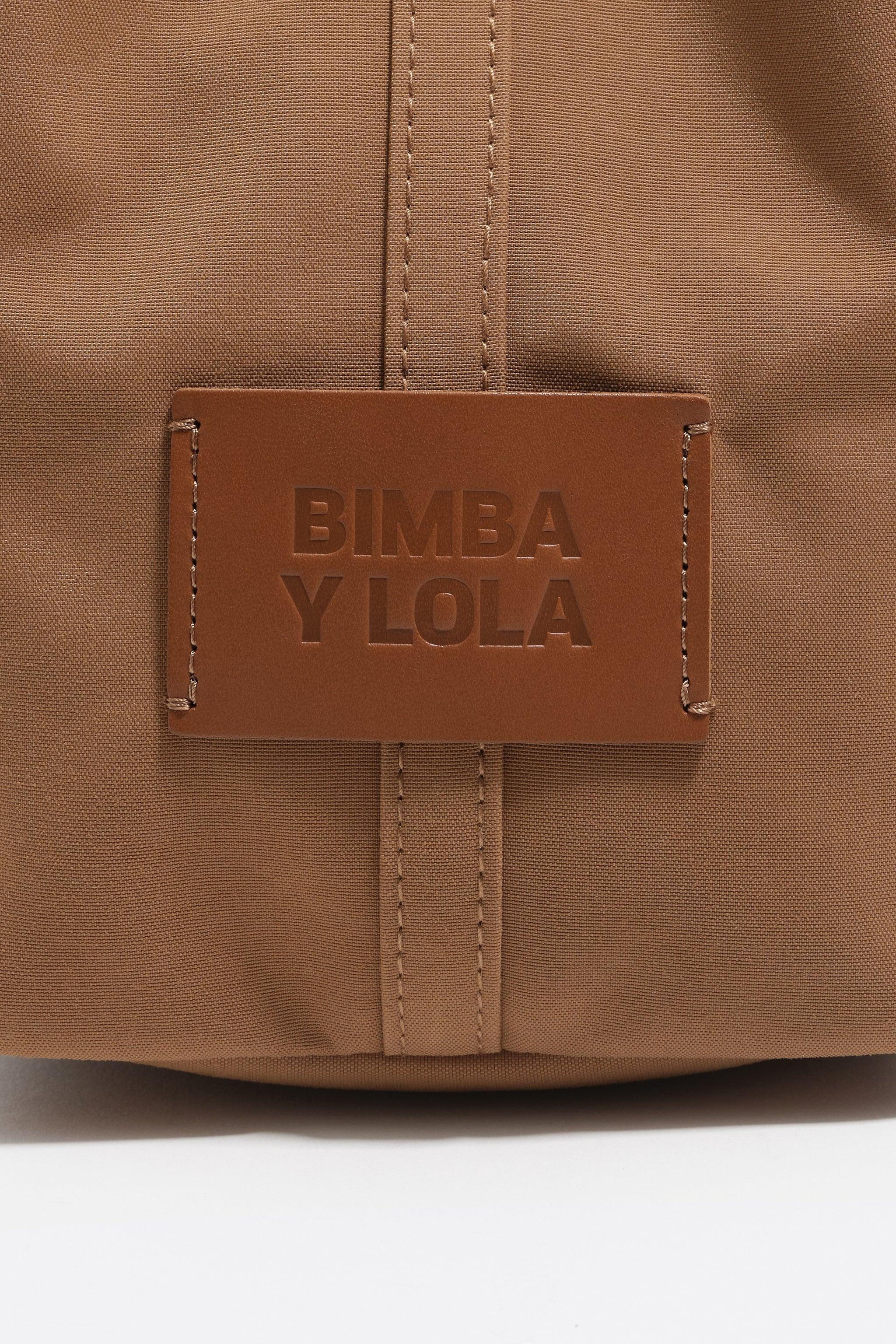 תקריב של תווית עור חומה עם כיתוב BIMBA Y LOLA על תיק אופנתי, מותג מוביל ב-CHOZEN