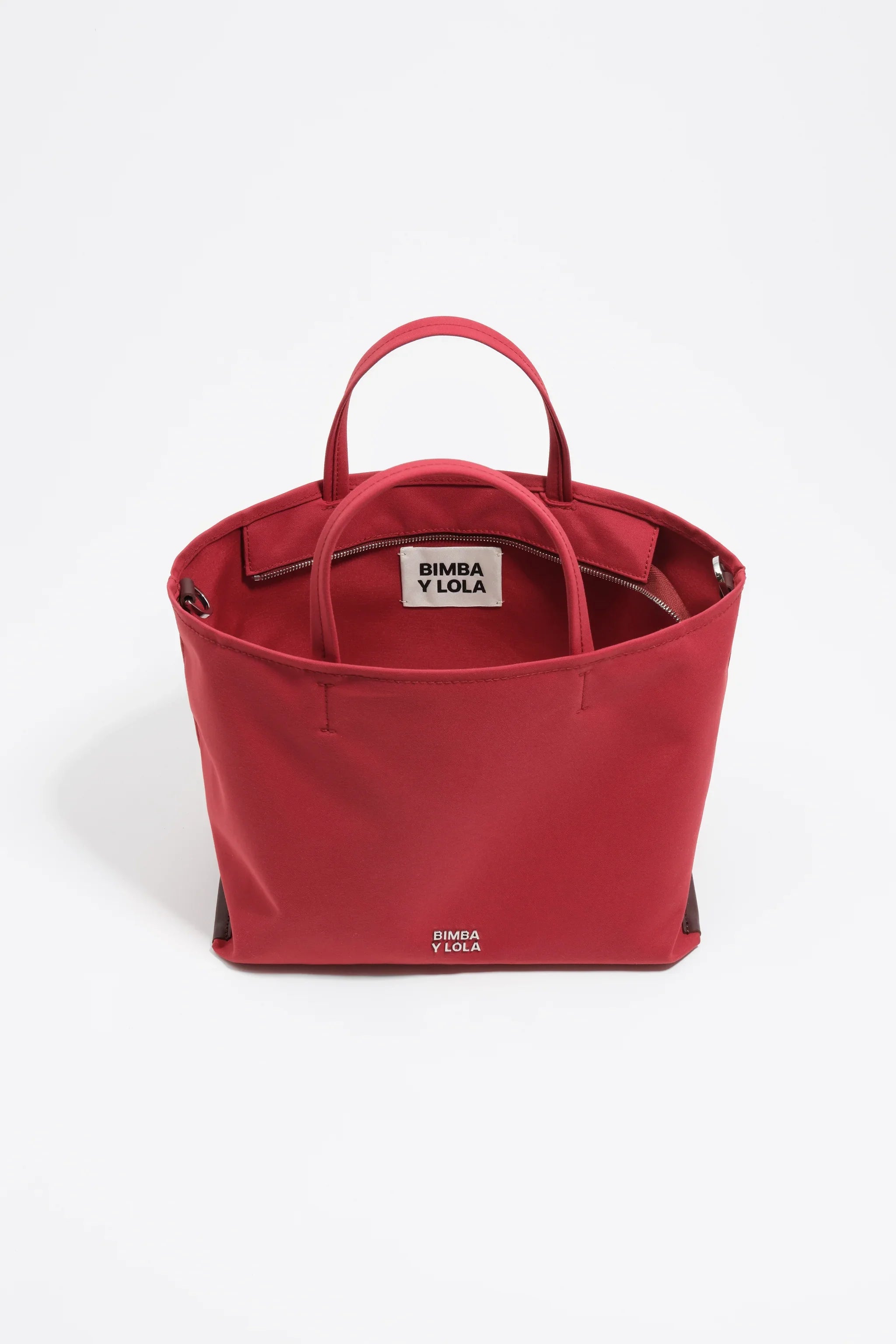 תיק יד אדום לנשים מבית BIMBA Y LOLA, עיצוב מודרני, מוצג על רקע לבן, CHOZEN