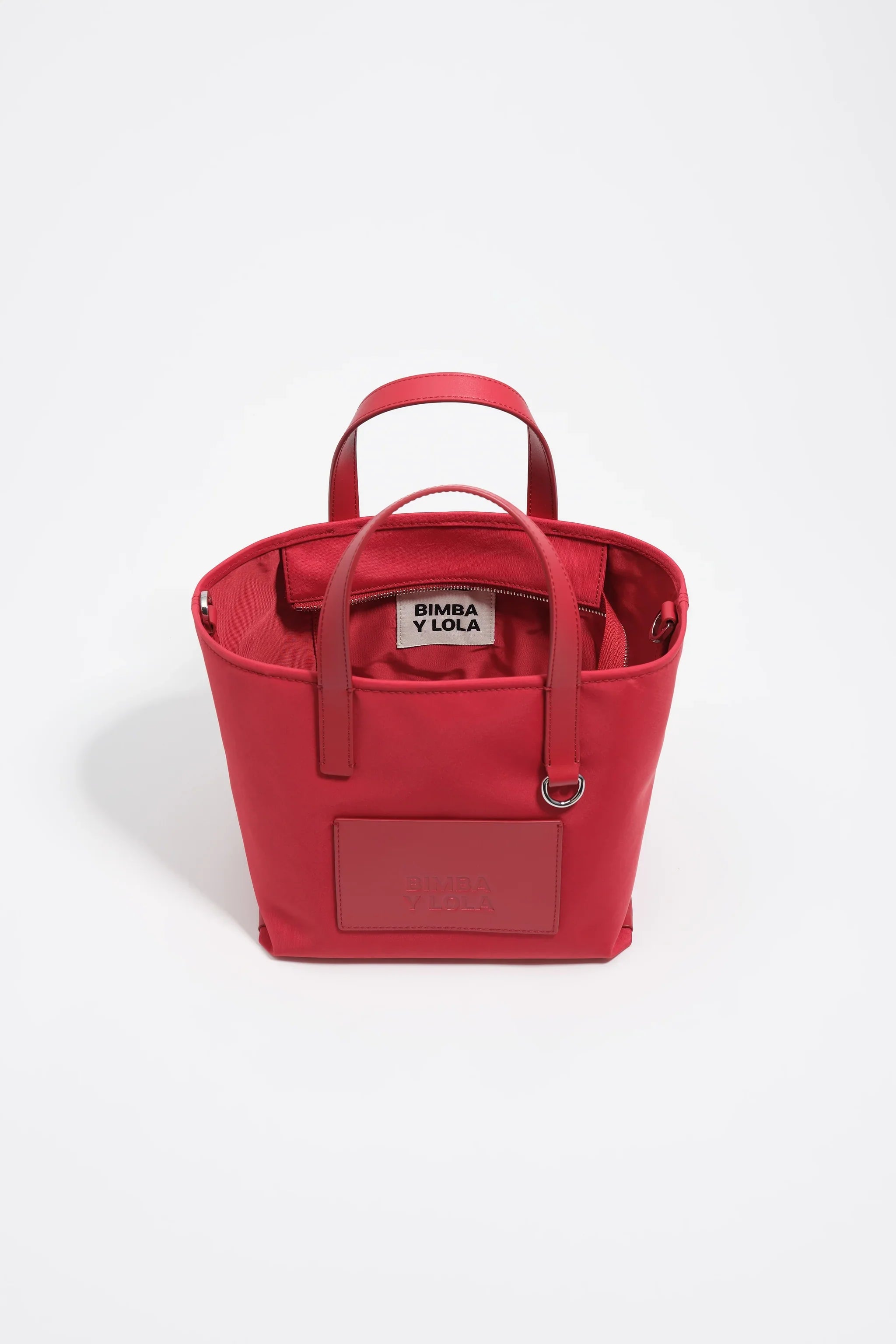 תיק יד נשי אדום של BIMBA Y LOLA, דגם טרנדי מיבוא קבוצת אלפא, מוצג על רקע לבן