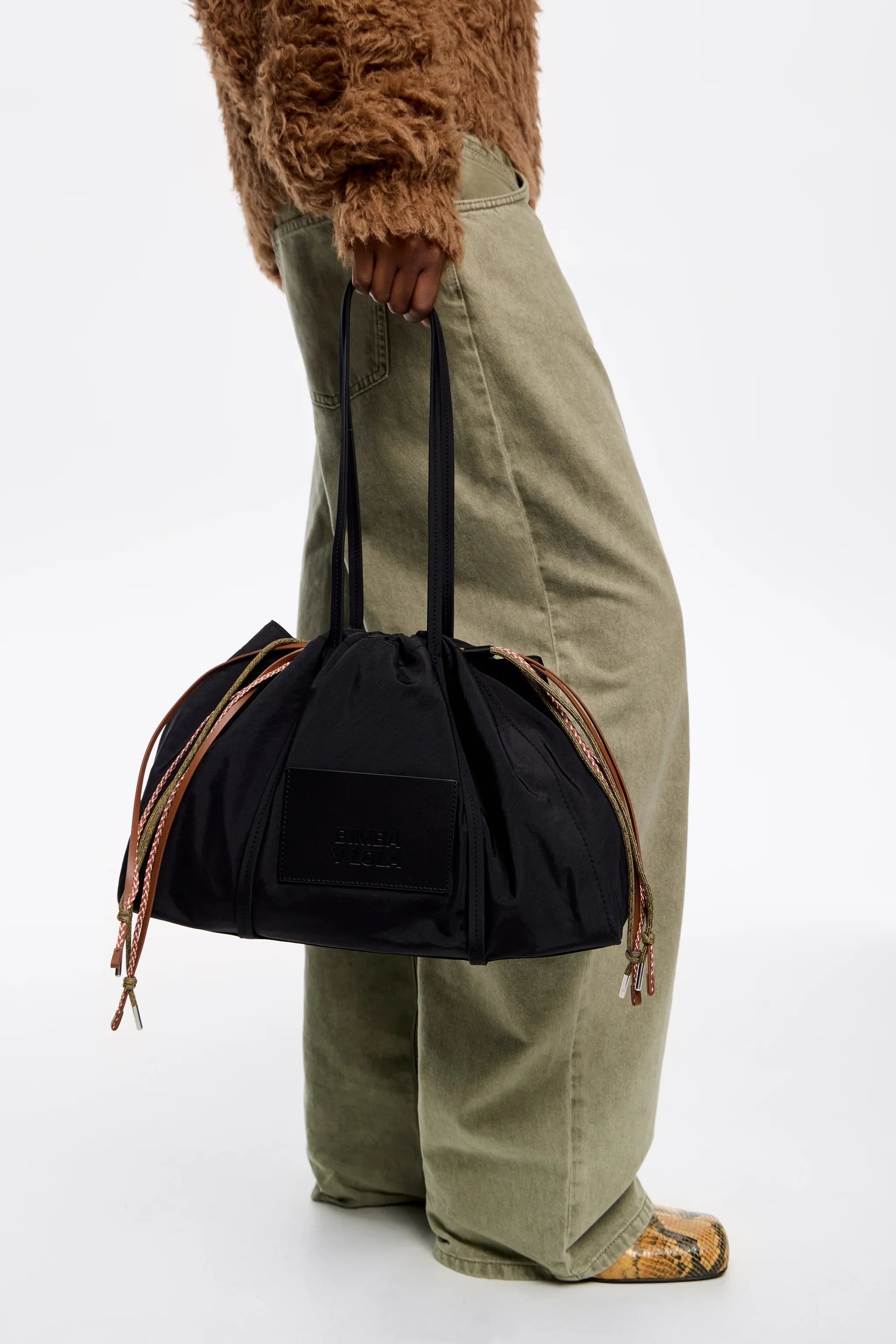 תיק נשיאה אופנתי שחור עם שרוכים ליד אישה בלבוש חורפי, CHOZEN אלפא מותגים מובילים