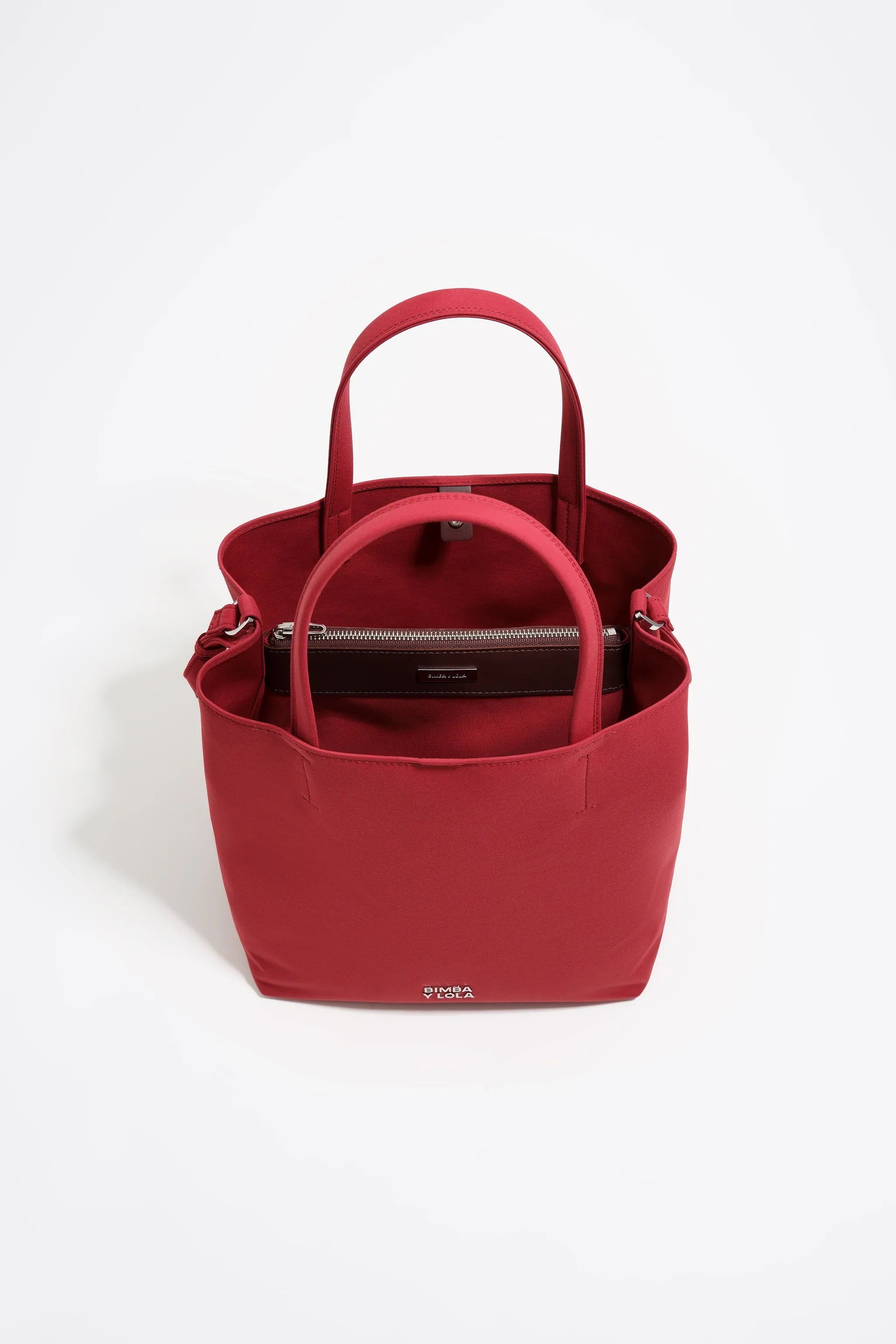 תיק נשיאה אדום אלגנטי של מותג יוקרתי ב-CHOZEN, קבוצת אלפא, מצולם על רקע לבן