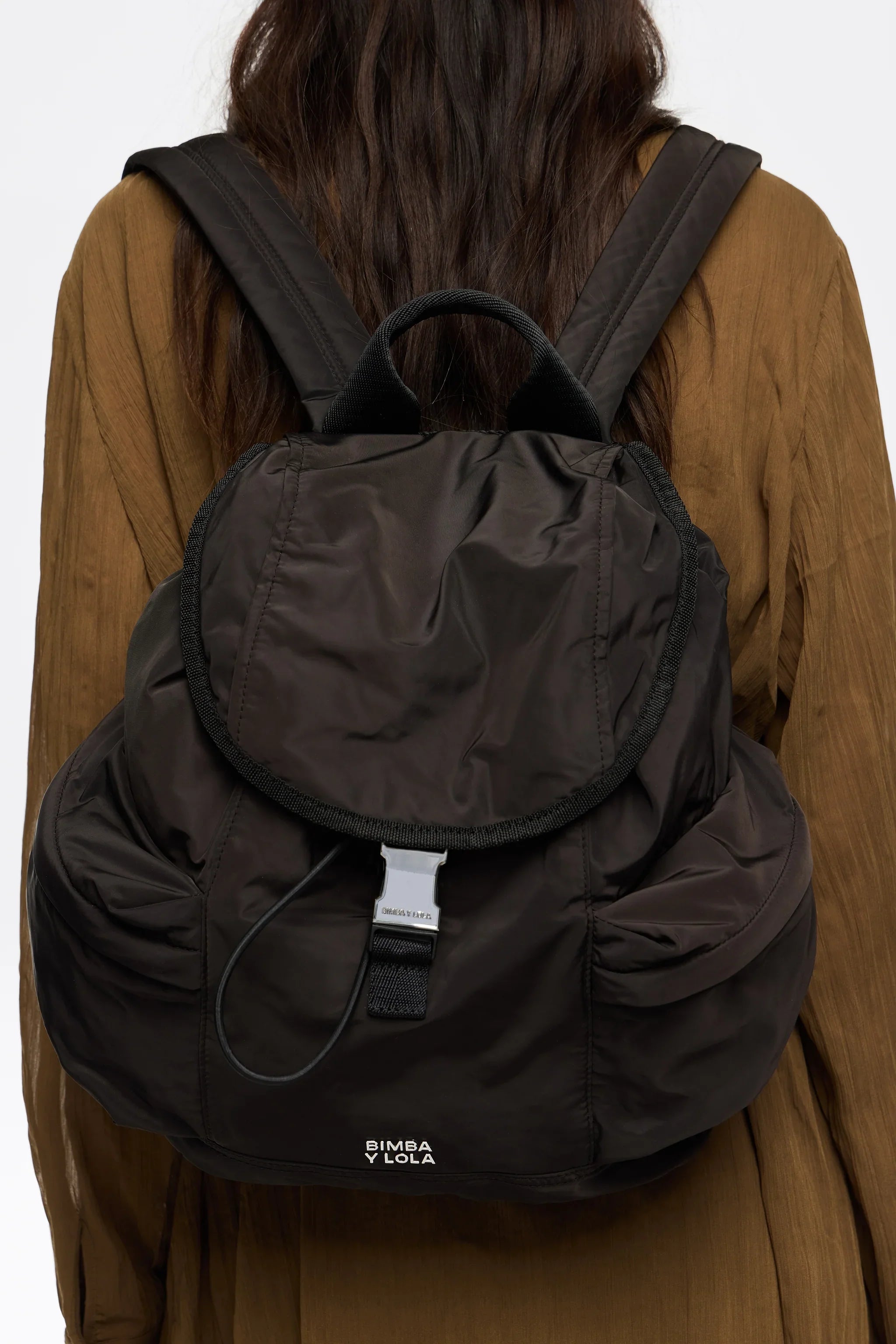 תיק גב שחור של BIMBA Y LOLA על גב אישה, נמכר ב-CHOZEN, מבית קבוצת אלפא