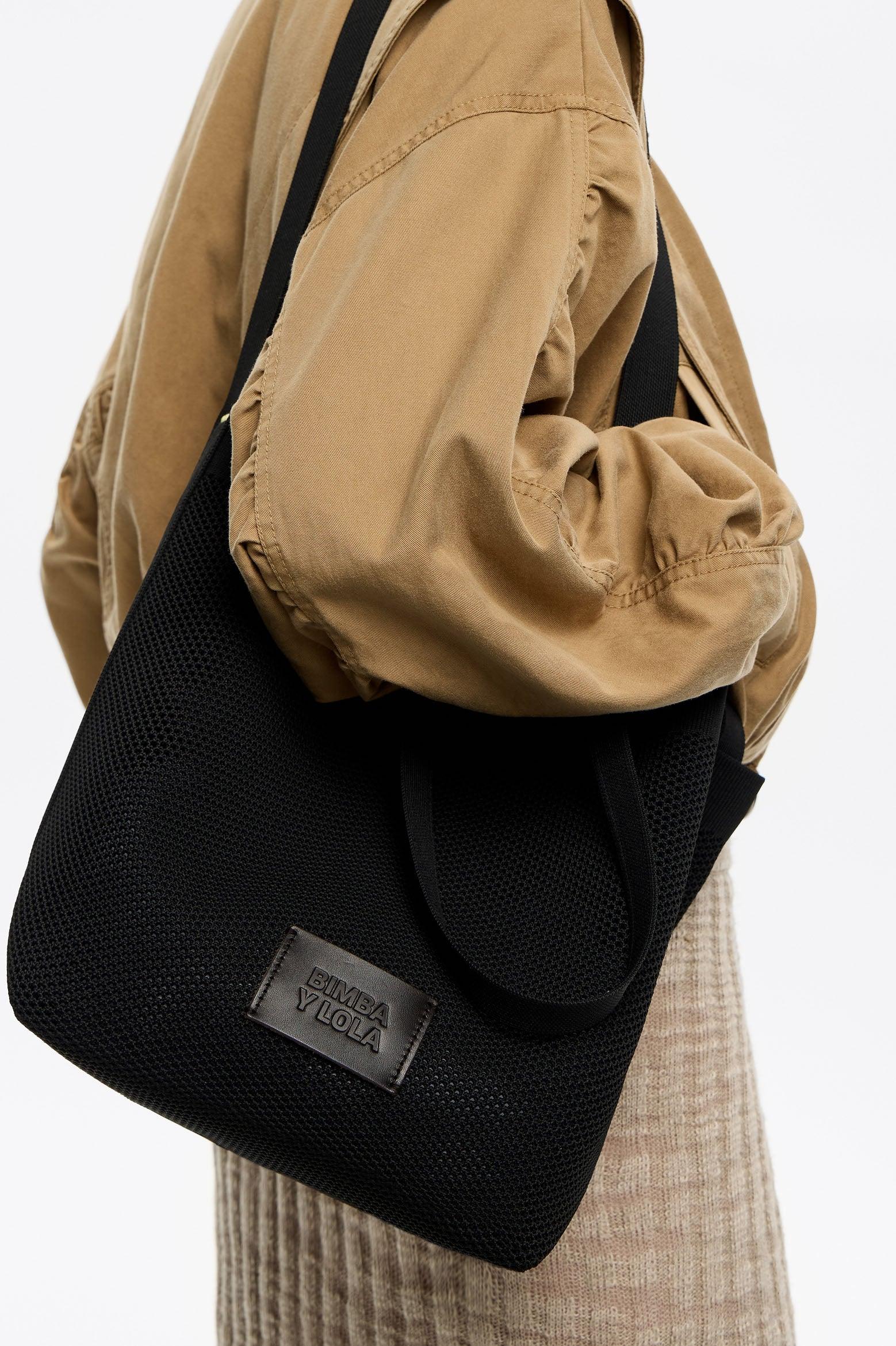 תיק כתף שחור Bimba Y Lola מבית CHOZEN על דוגמנית עם מעיל בז'