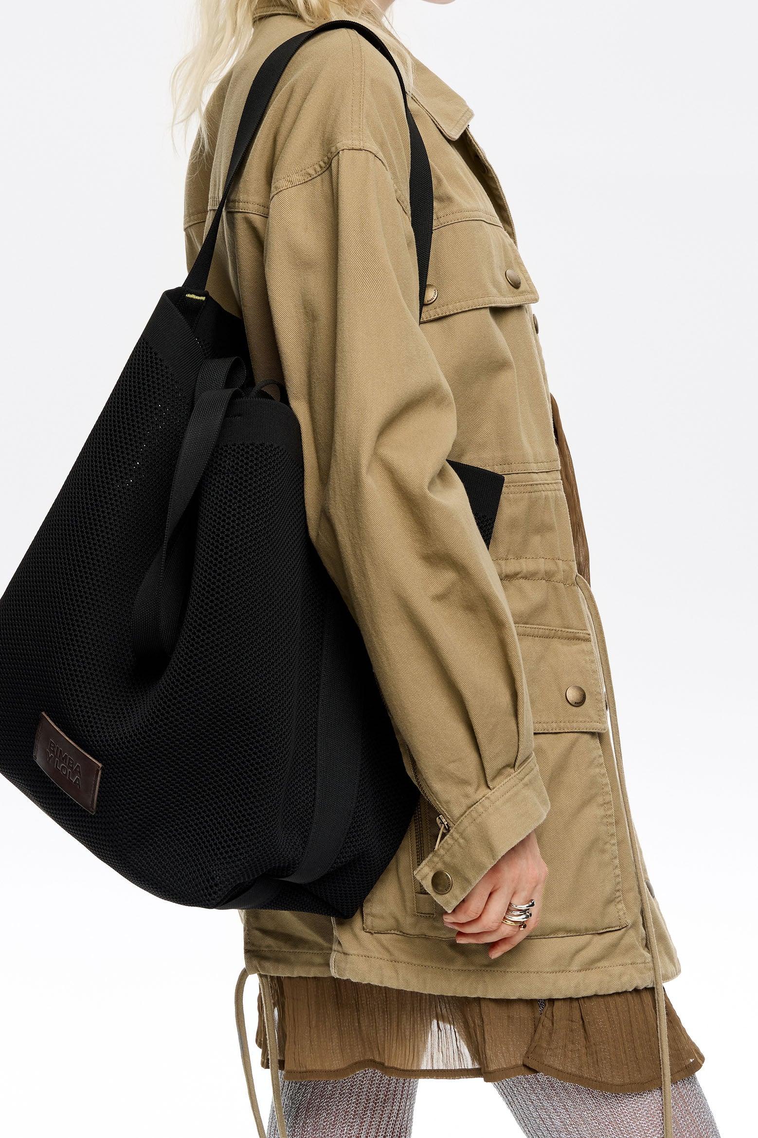 אישה עם מעיל בז' ותיק שחור על הכתף, אופנה עדכנית מ-CHOZEN