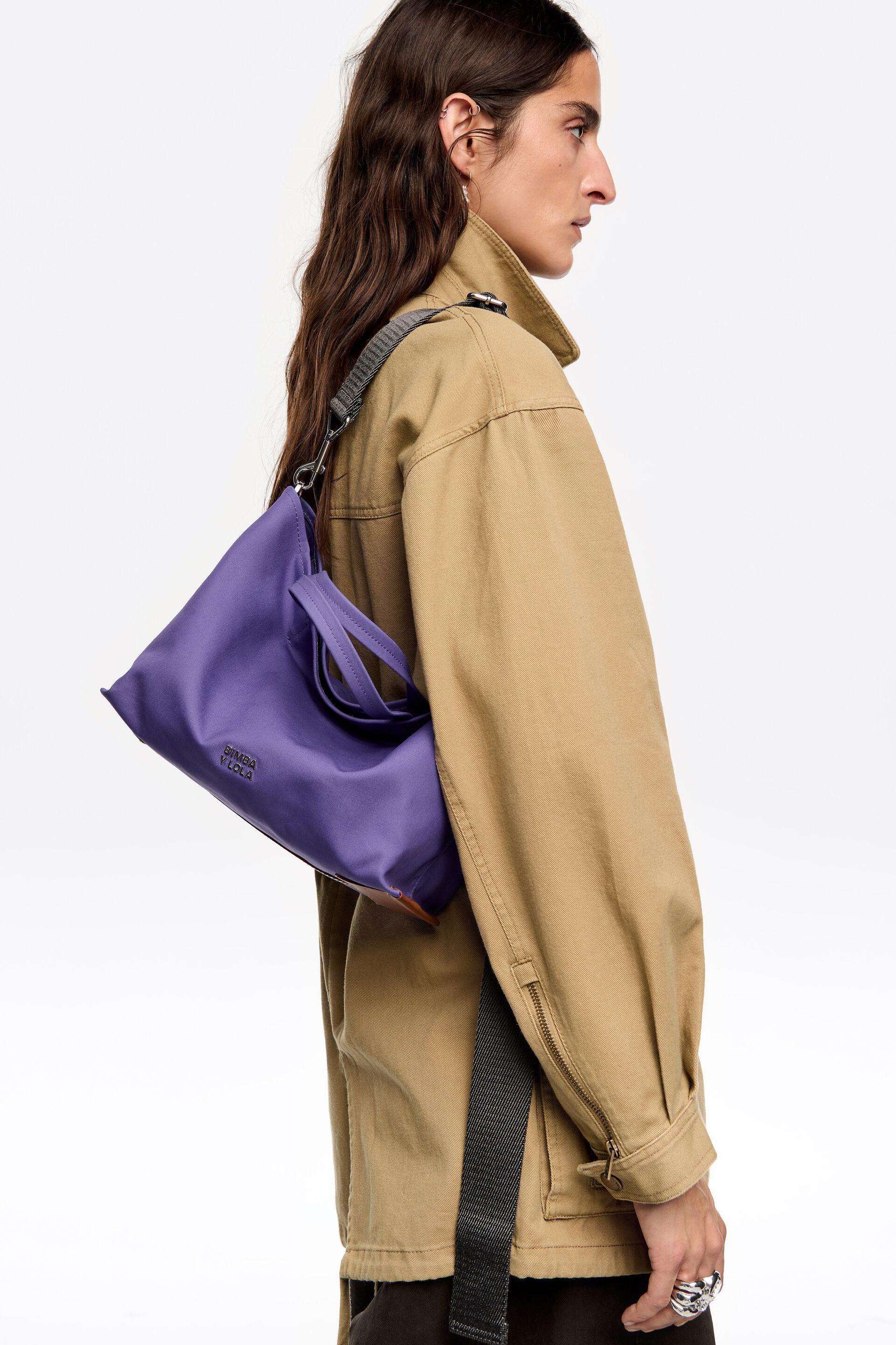 דוגמן עם תיק סגול מבית Bimba Y Lola ל-CHOZEN, לבוש מעיל בז', אופנת מותגים מובילים