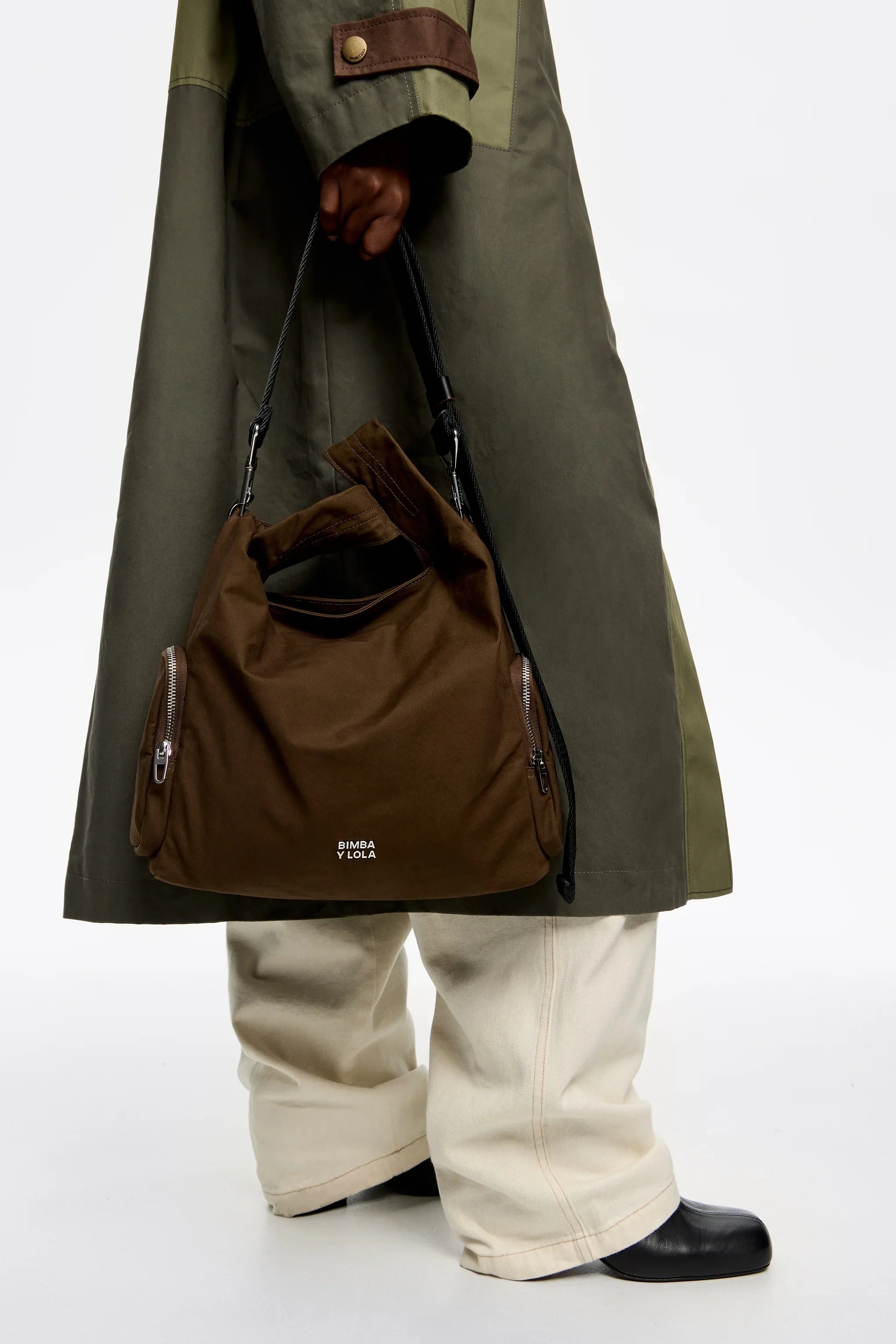 תיק Bimba Y Lola חום, מוחזק ביד עם מעיל ירוק ובגדי אופנה, מותגים מובילים ב-CHOZEN